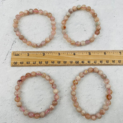 bracelets next to a ruler for size reference 