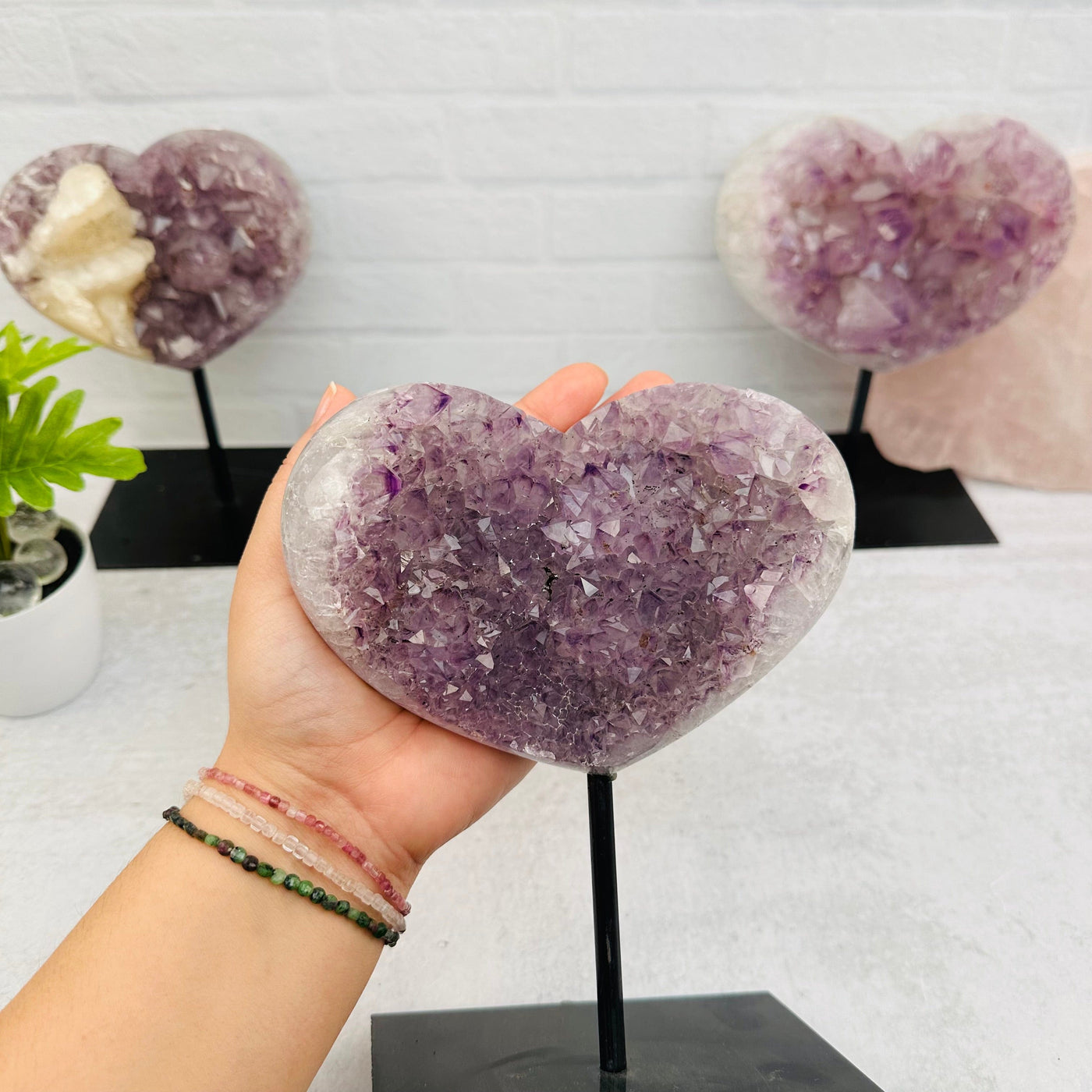 Amethyst Crystal Heart on Stand in hand for size reference 