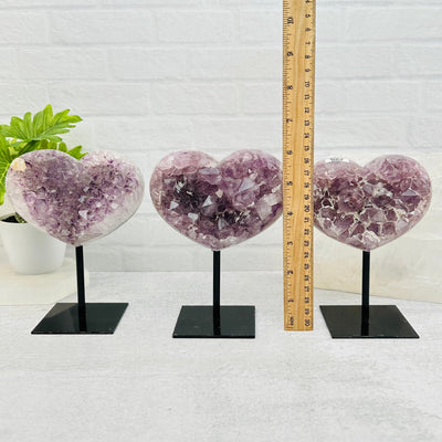 amethyst hearts next to a ruler for size reference 