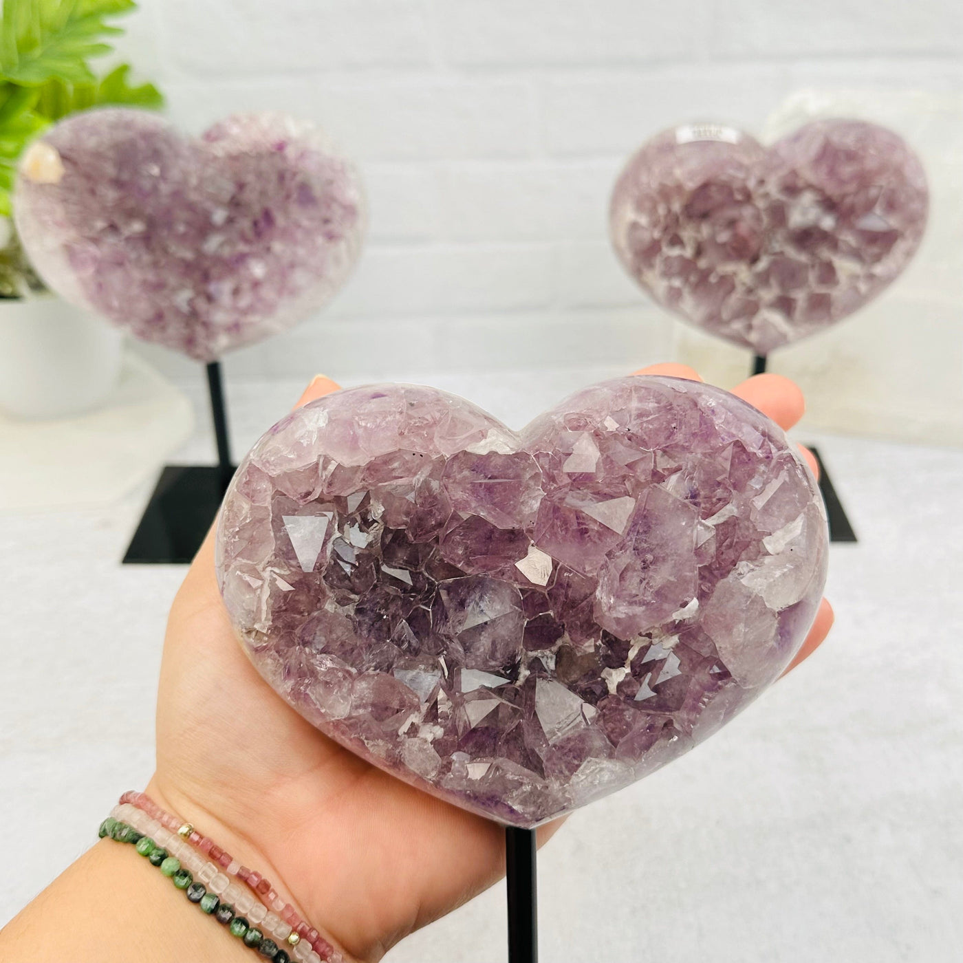 Amethyst Crystal Heart on Stand in hand for size reference 