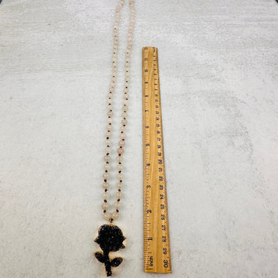 mala necklace next to a ruler for size reference 