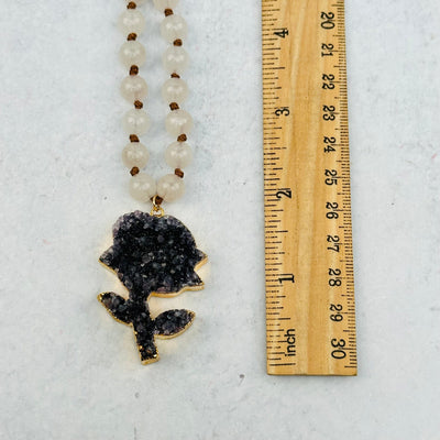 pendant next to a ruler for size reference 