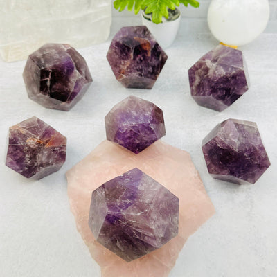 multiple Amethyst Crystal Dodecahedrons displayed to show the difference in the color shades and sizes 