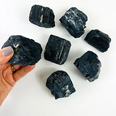 Tourmaline Crystal Chunks with 1 in a hand for size reference
