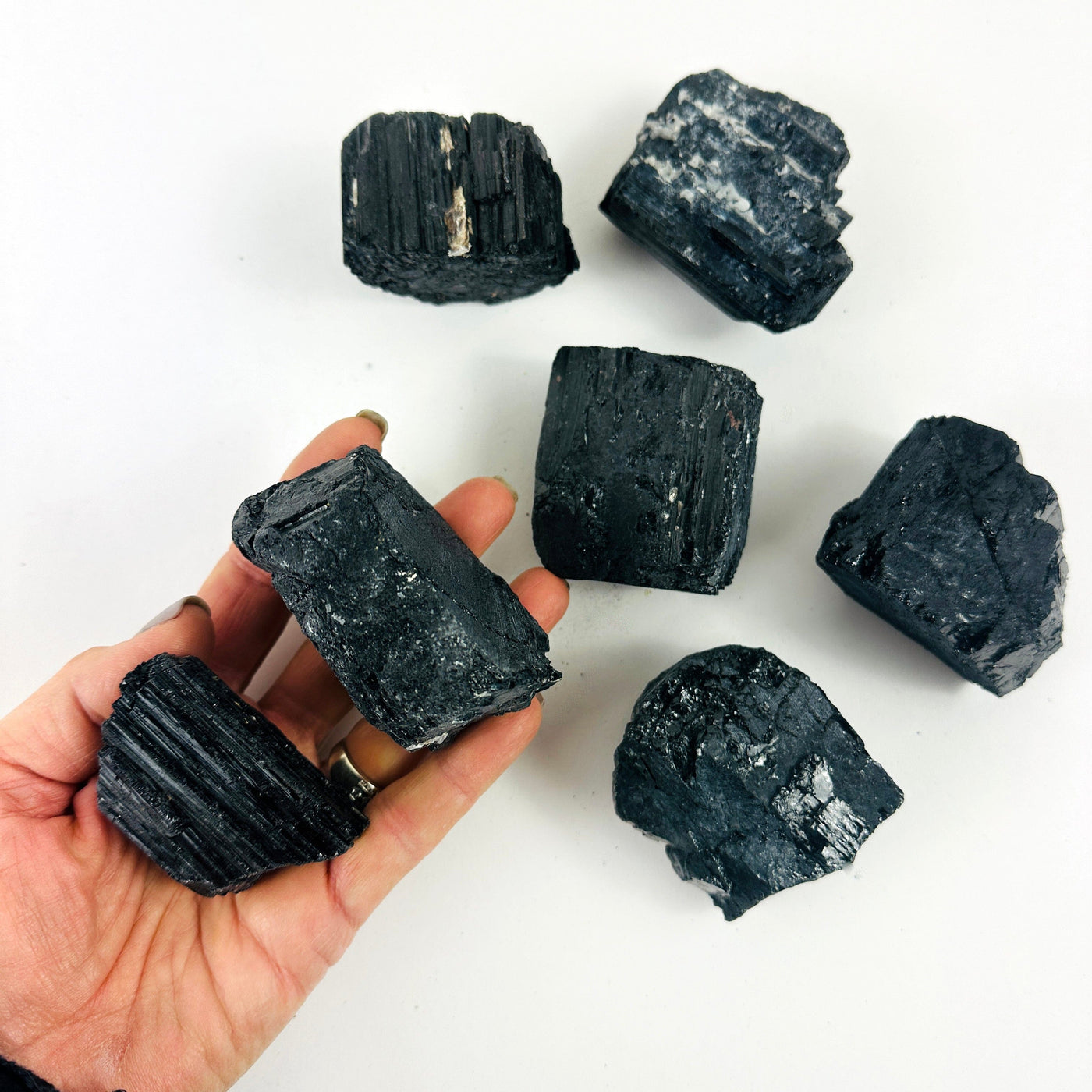 Tourmaline Crystal Chunkswith one in a hand for size reference