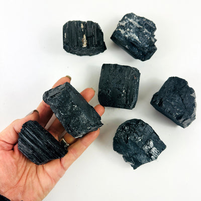 Tourmaline Crystal Chunkswith one in a hand for size reference