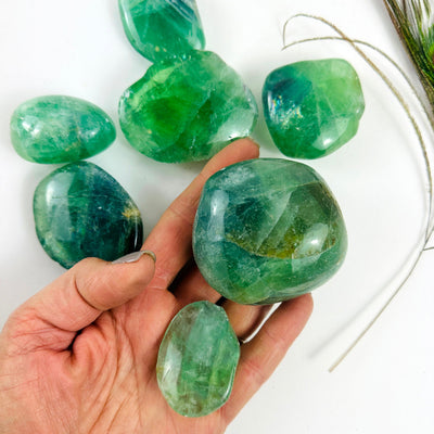 Seven Fluorite Crystal Polished Stones with some in a hand for size reference
