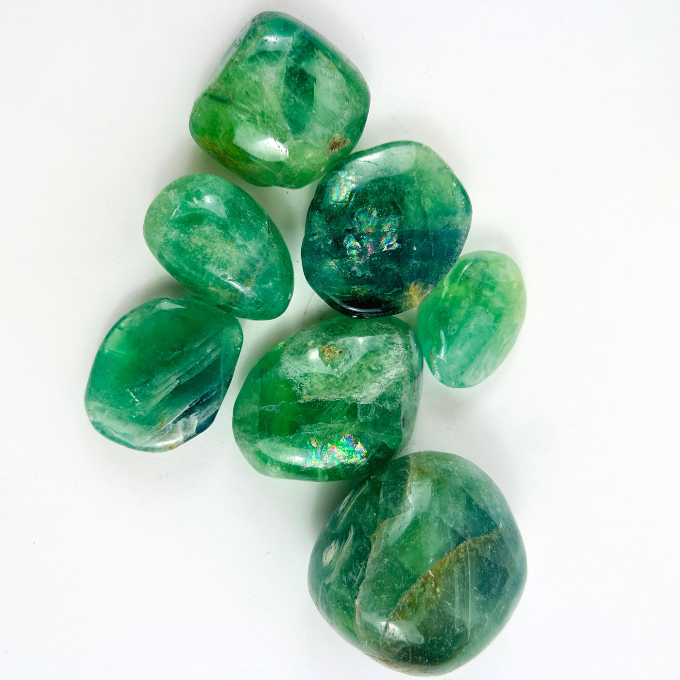 Seven Fluorite Crystal Polished Stones on a table