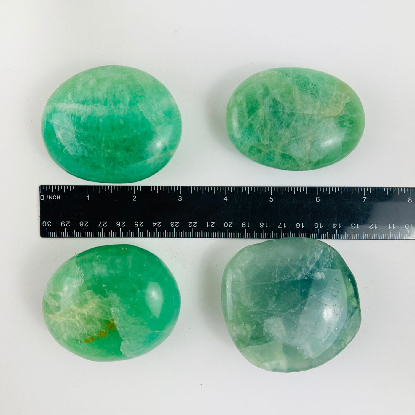 Fluorite Crystal Palm Stones next to a ruler showing size