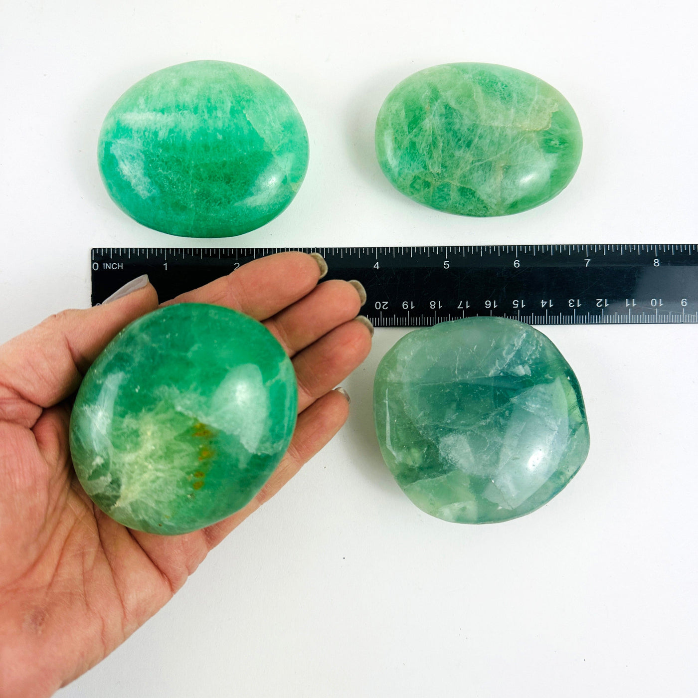 Fluorite Crystal Palm Stones  with one in a hand for size reference