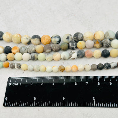 beads next to a ruler for size reference 