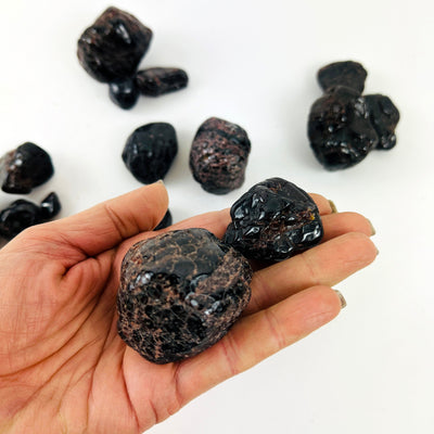 Tumbled Garnet Crystals with some in a hand for size reference