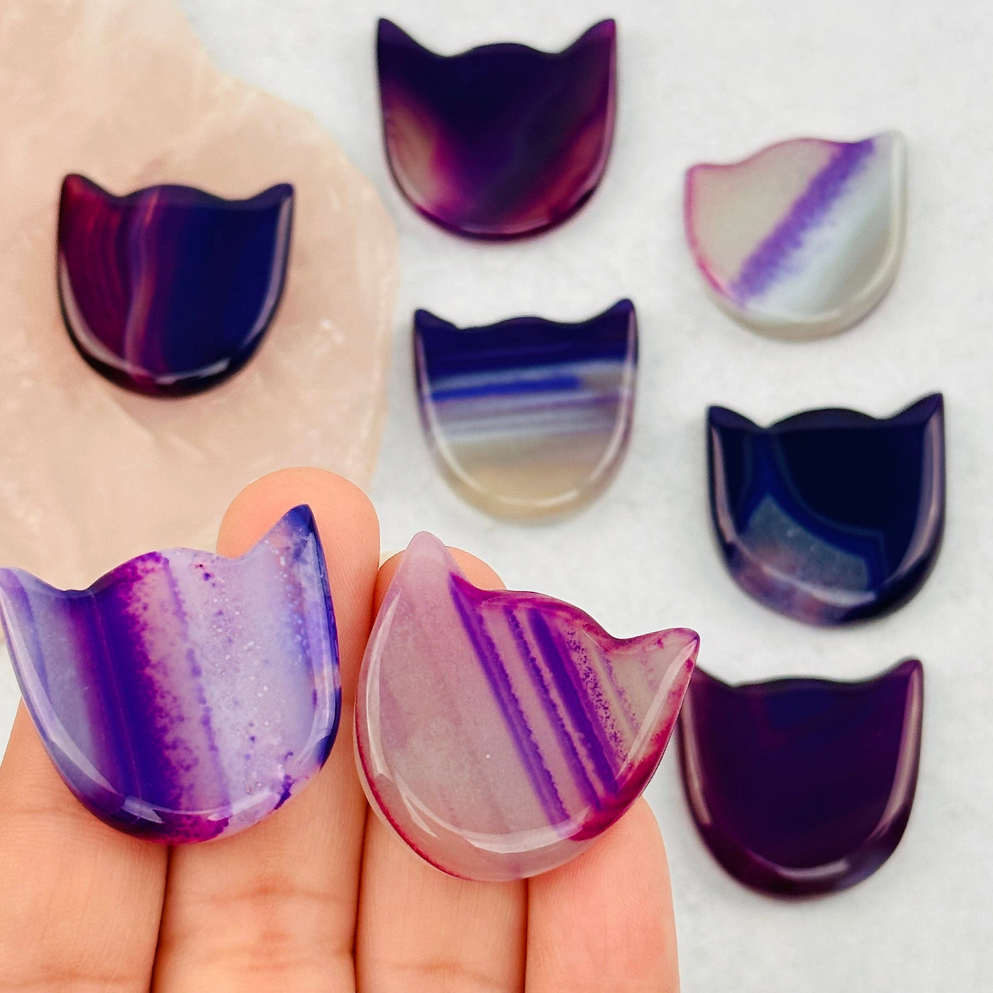 purple agate cats in hand for size reference 