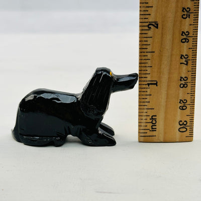 Carved Crystal Dog next to a ruler for size reference 