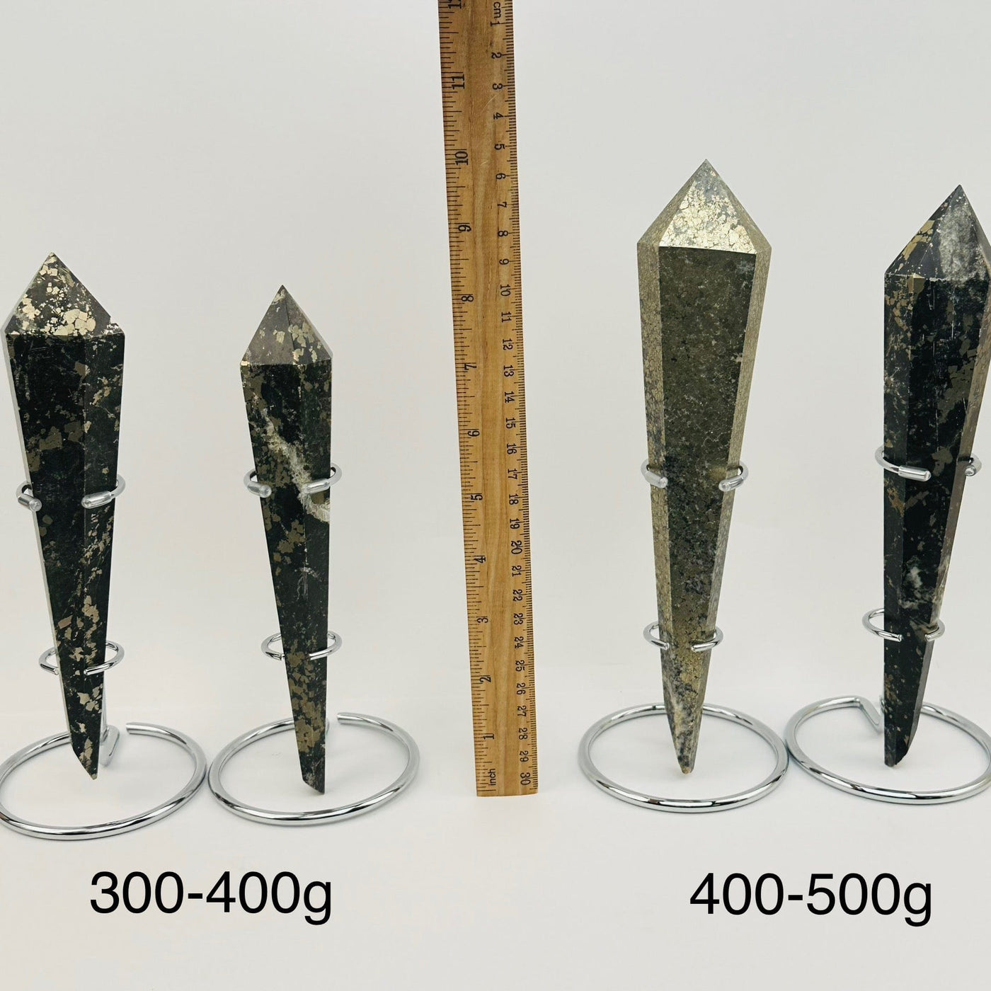 crystal wands on metal stand are sold by weight. displayed next to a ruler for size reference 