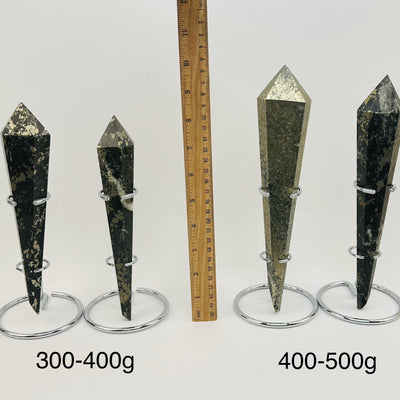 crystal wands on metal stand are sold by weight. displayed next to a ruler for size reference 