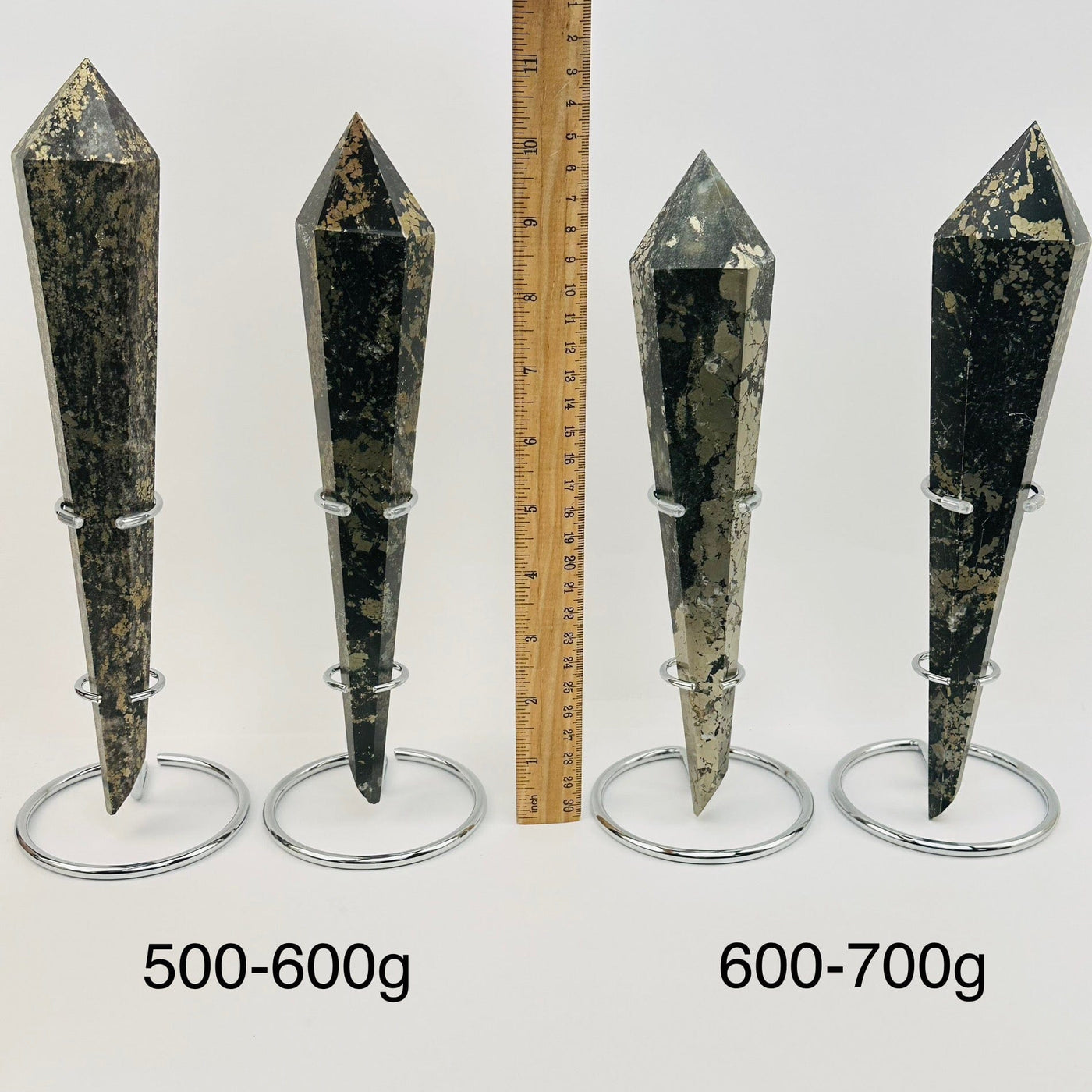 crystal wands on metal stand are sold by weight. displayed next to a ruler for size reference 