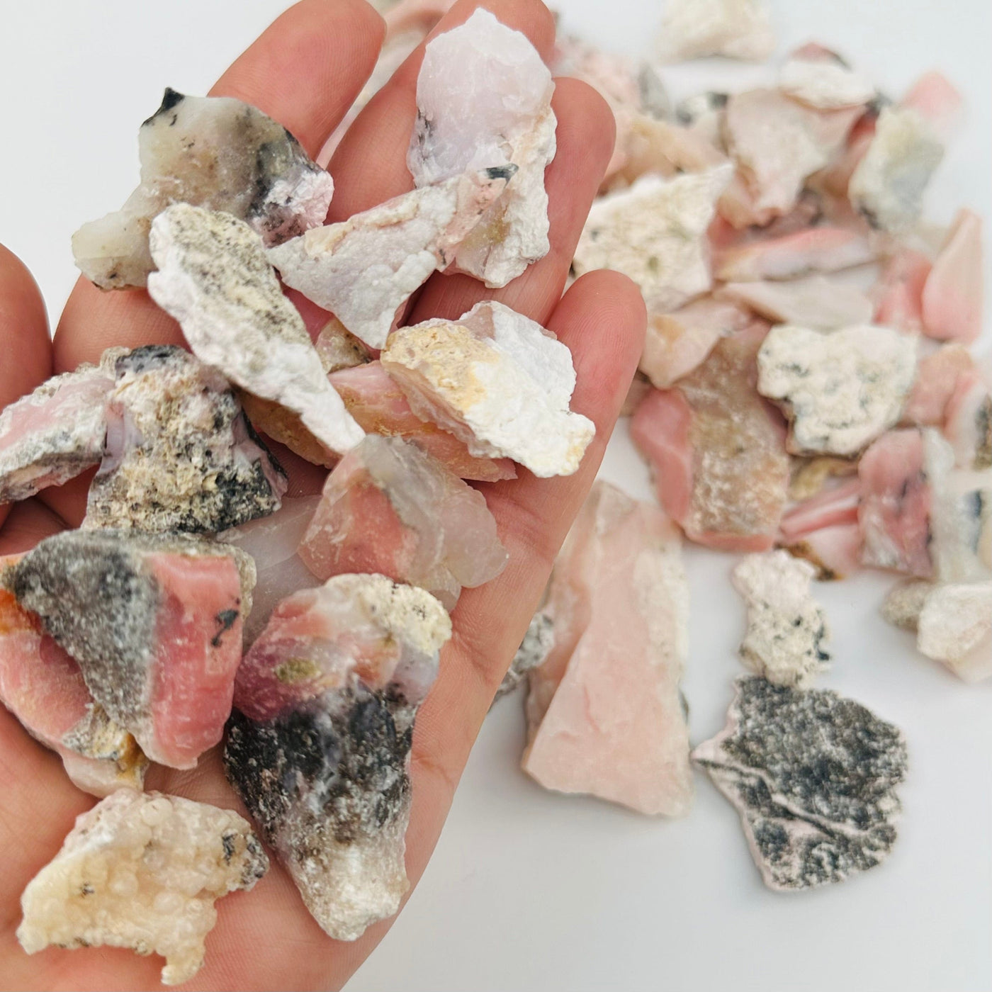 Rough Pink Opal Crystal Stones in hand for size reference 