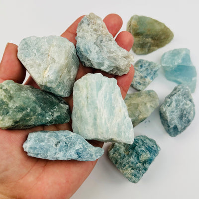 Rough Aquamarine Crystal Stones in hand for size reference 
