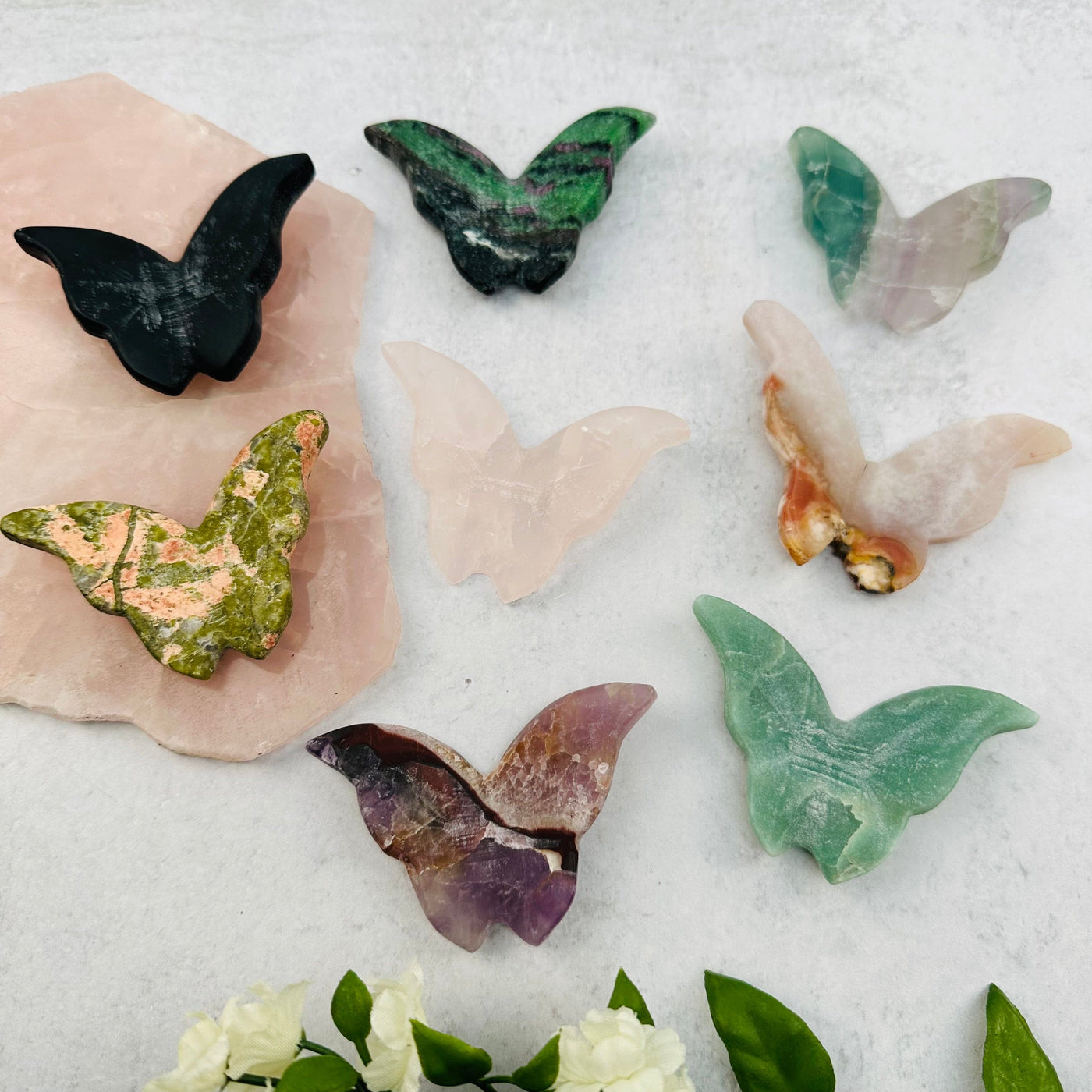 multiple gemstone butterflies displayed to show the differences in the crystal types 