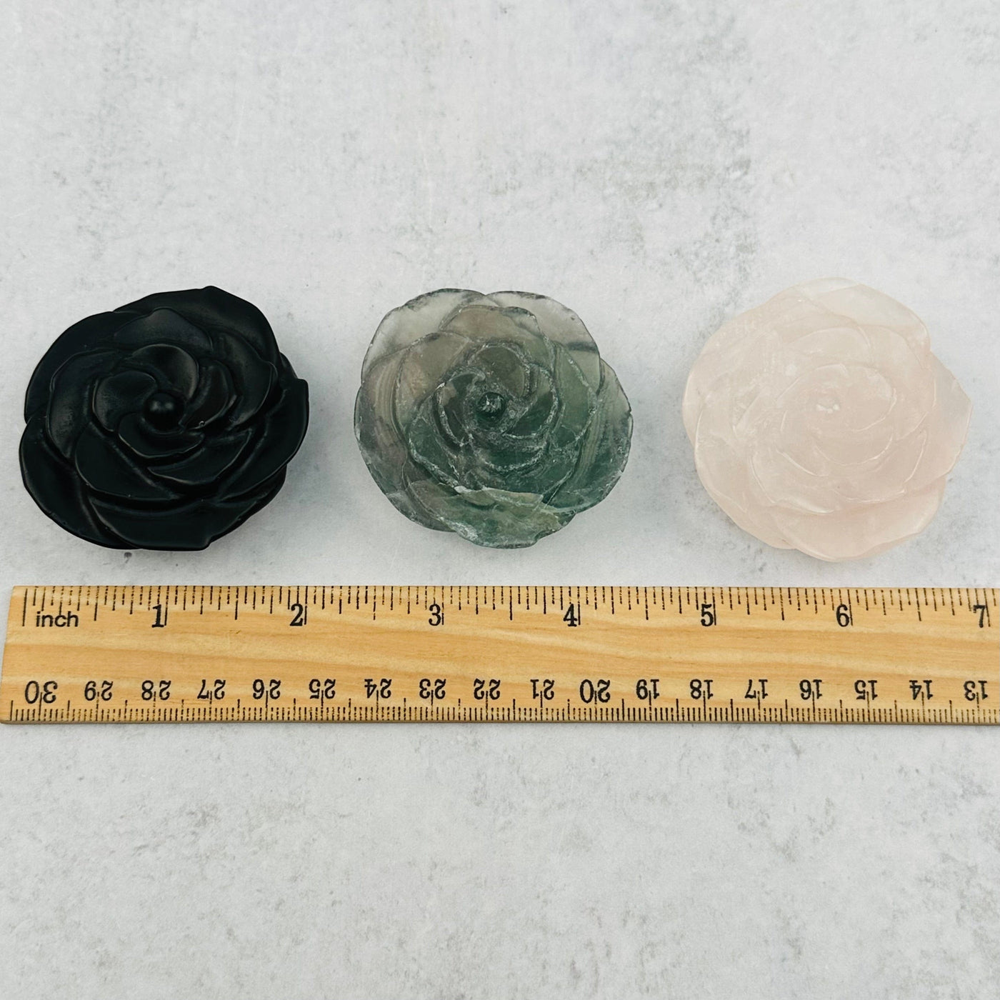 Gemstone Hand Carved Open Rose next to a ruler for size reference 