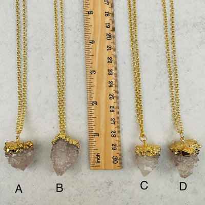 close up of the cactus quartz pendants next to a ruler for size reference 