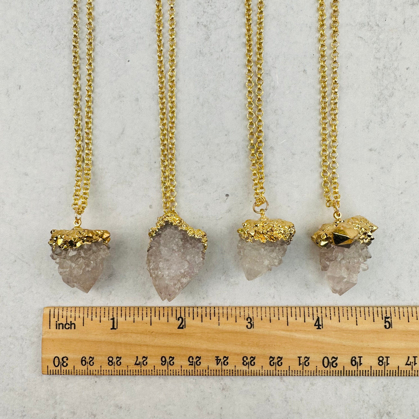 close up of the cactus quartz pendants next to a ruler for size reference