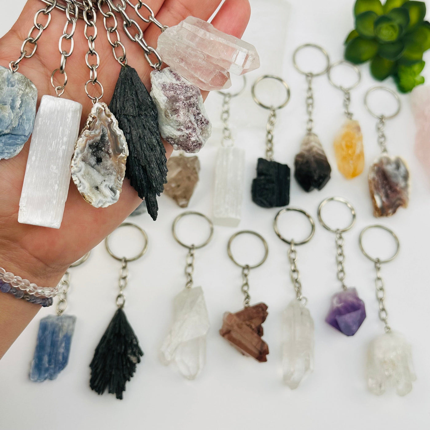 multiple crystal key chains in hand for size reference 