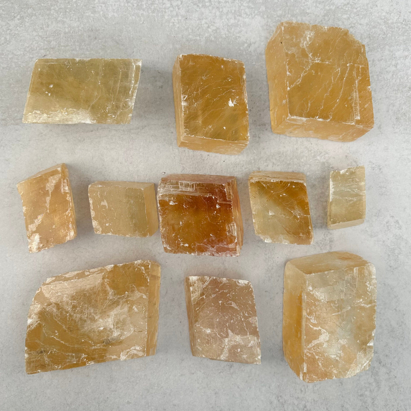 multiple Yellow Optical Calcite pieces displayed to show the differences in the color shades and sizes 