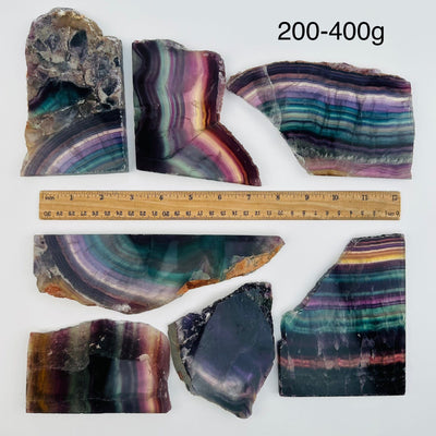 fluorite semi polished crystal slabs sold by weight. displayed next to a ruler for size reference 