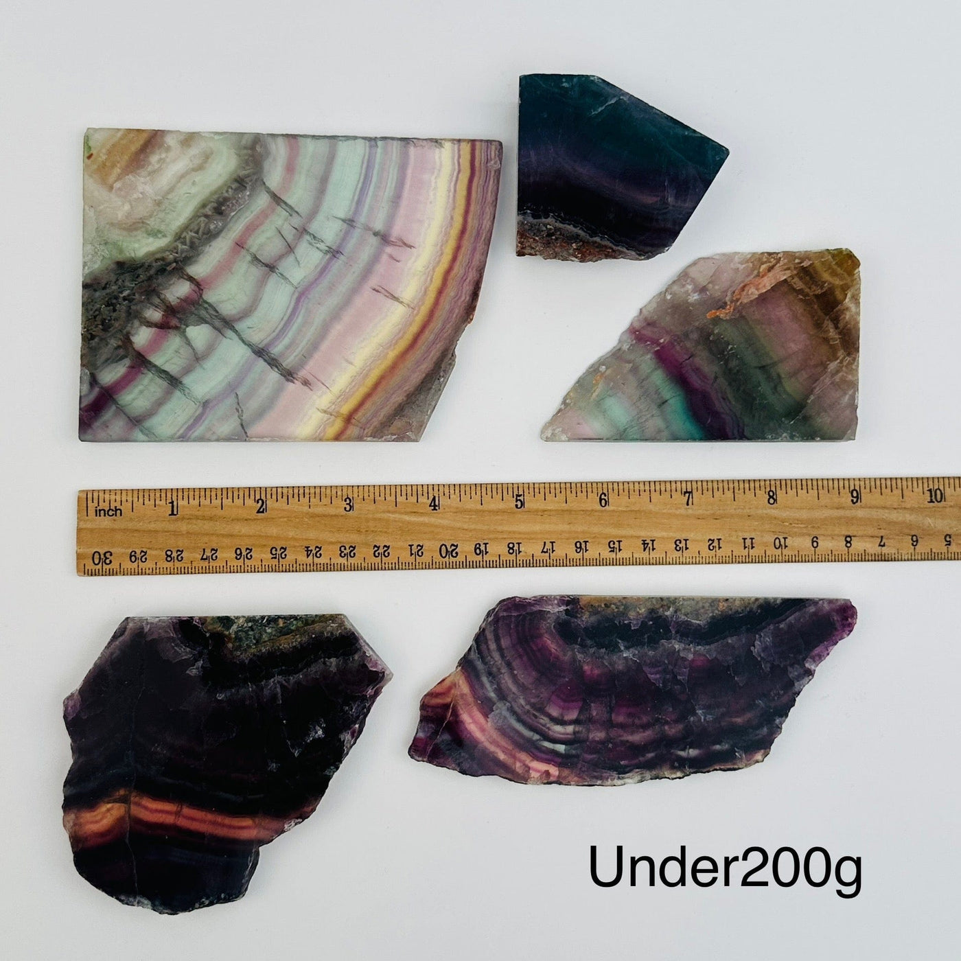 fluorite semi polished crystal slabs sold by weight. displayed next to a ruler for size reference 