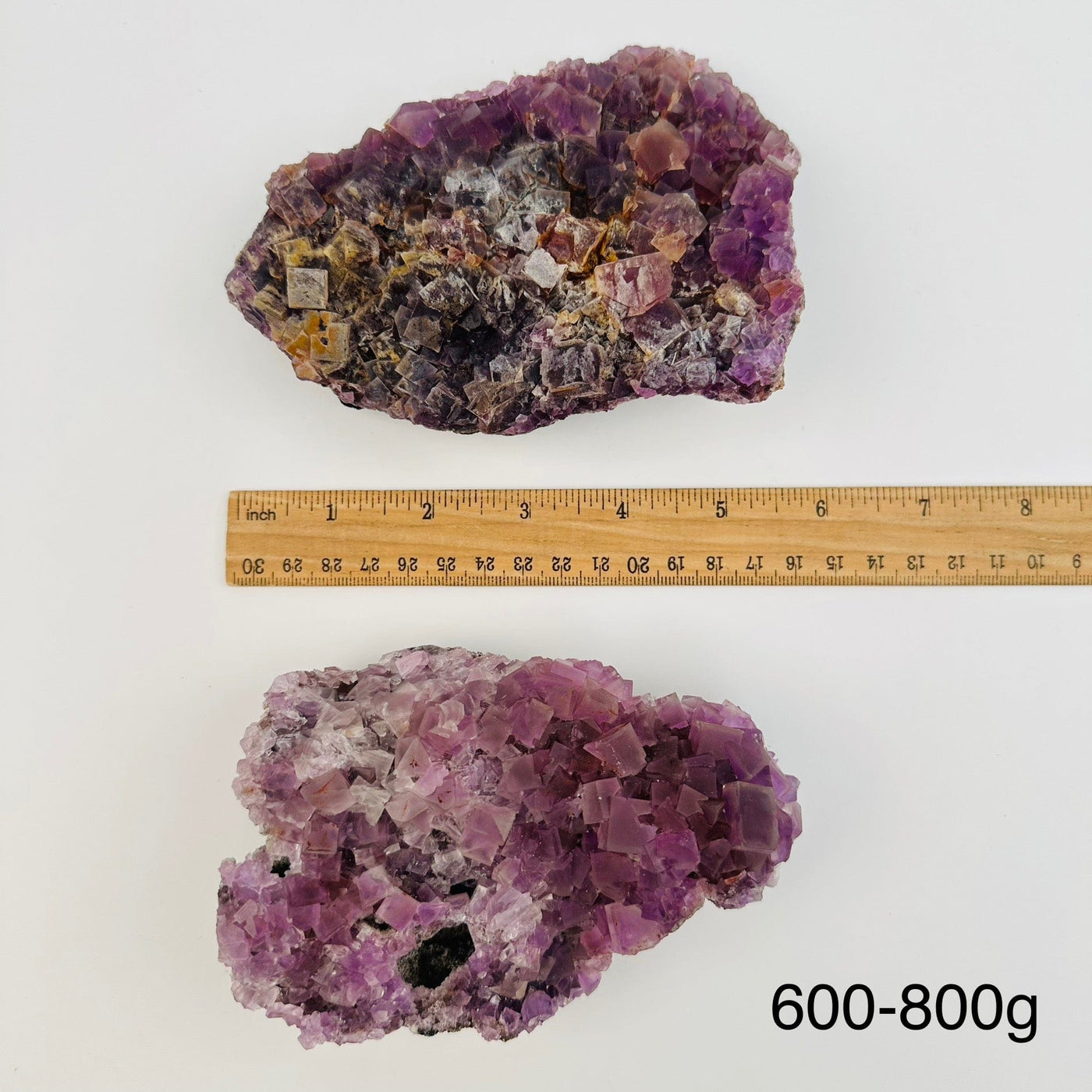 fluorite crystal clusters sold by weight. displayed next to a ruler for size reference 