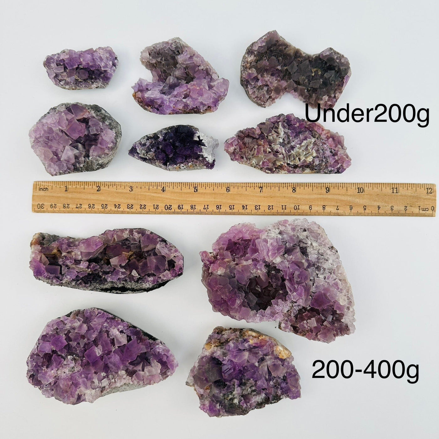 fluorite crystal clusters sold by weight. displayed next to a ruler for size reference 