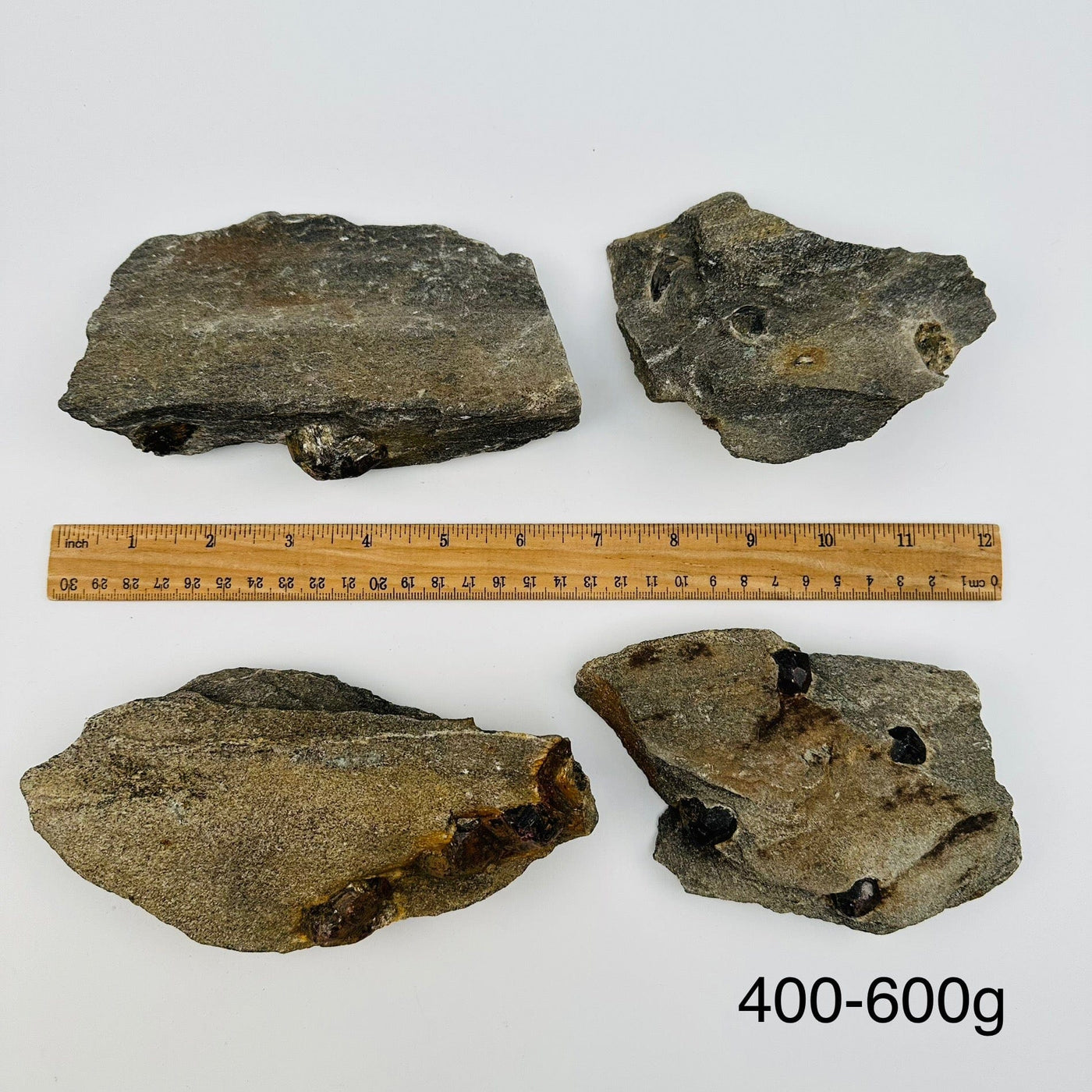 Garnet Crystals in Mica Schist sold by weight. displayed next to a ruler for size reference 