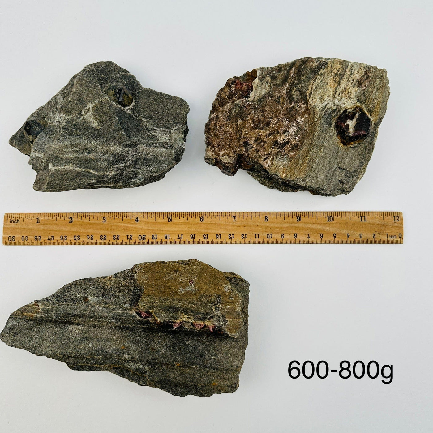 Garnet Crystals in Mica Schist sold by weight. displayed next to a ruler for size reference 