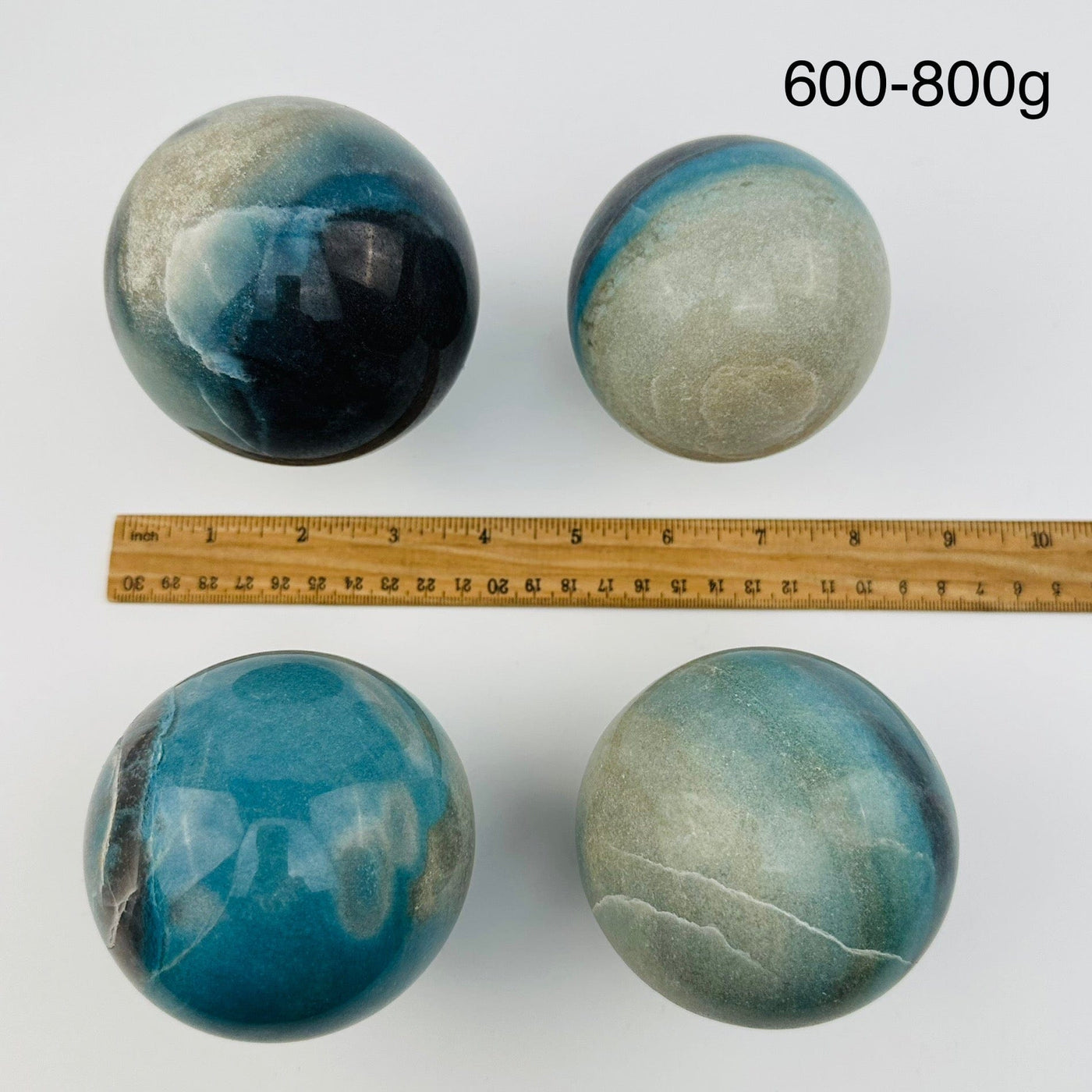 crystal trolleite spheres sold by weight. displayed next to a ruler for size reference 