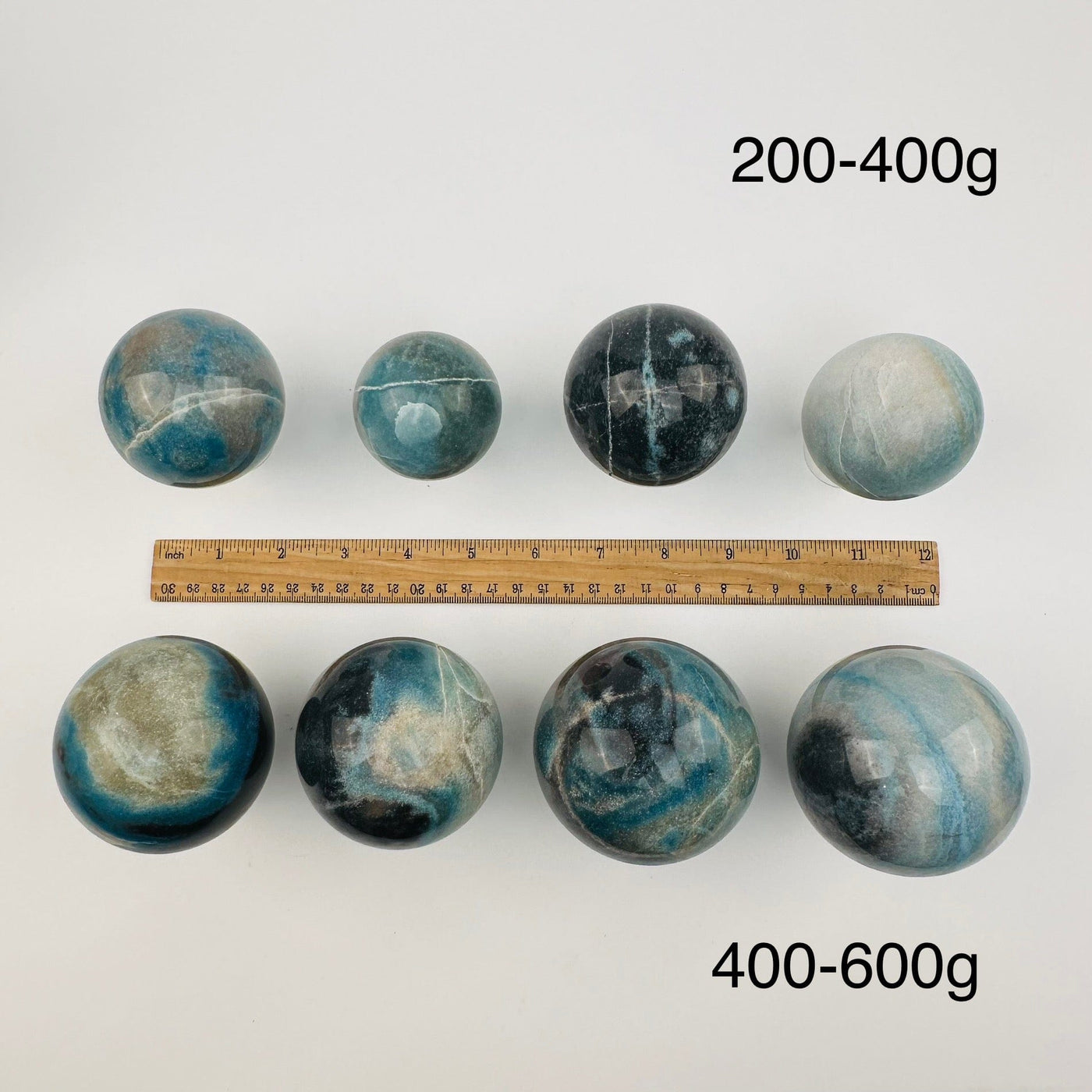 crystal trolleite spheres sold by weight. displayed next to a ruler for size reference 