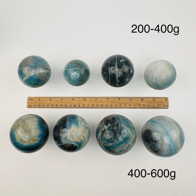 crystal trolleite spheres sold by weight. displayed next to a ruler for size reference 