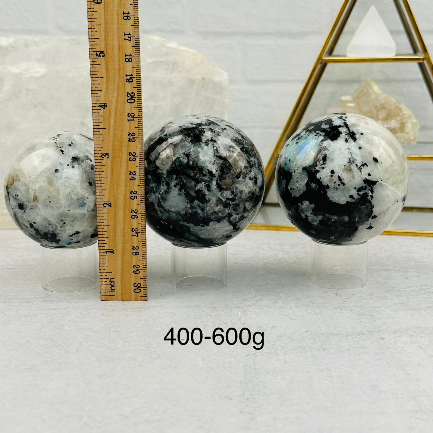 Rainbow Moonstone Sphere by Weight next to a ruler for size reference 