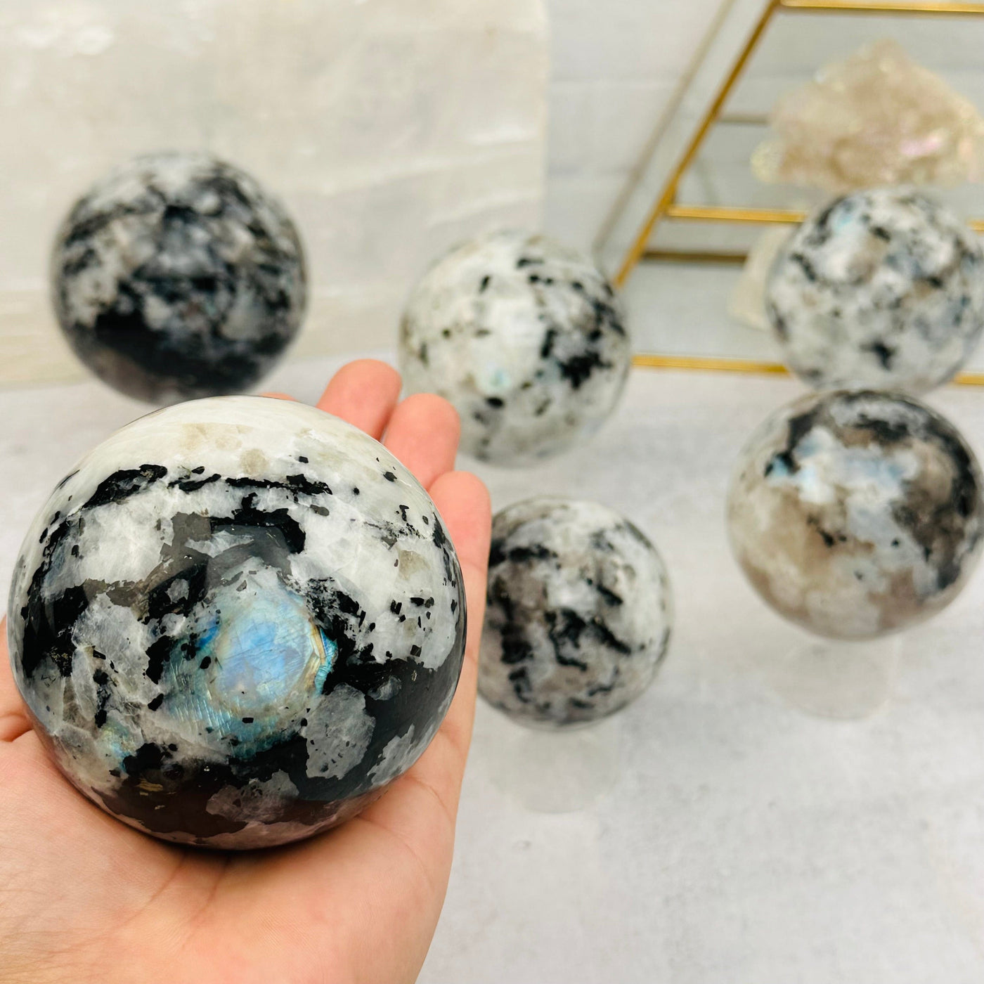 Rainbow Moonstone Sphere in hand for size reference 