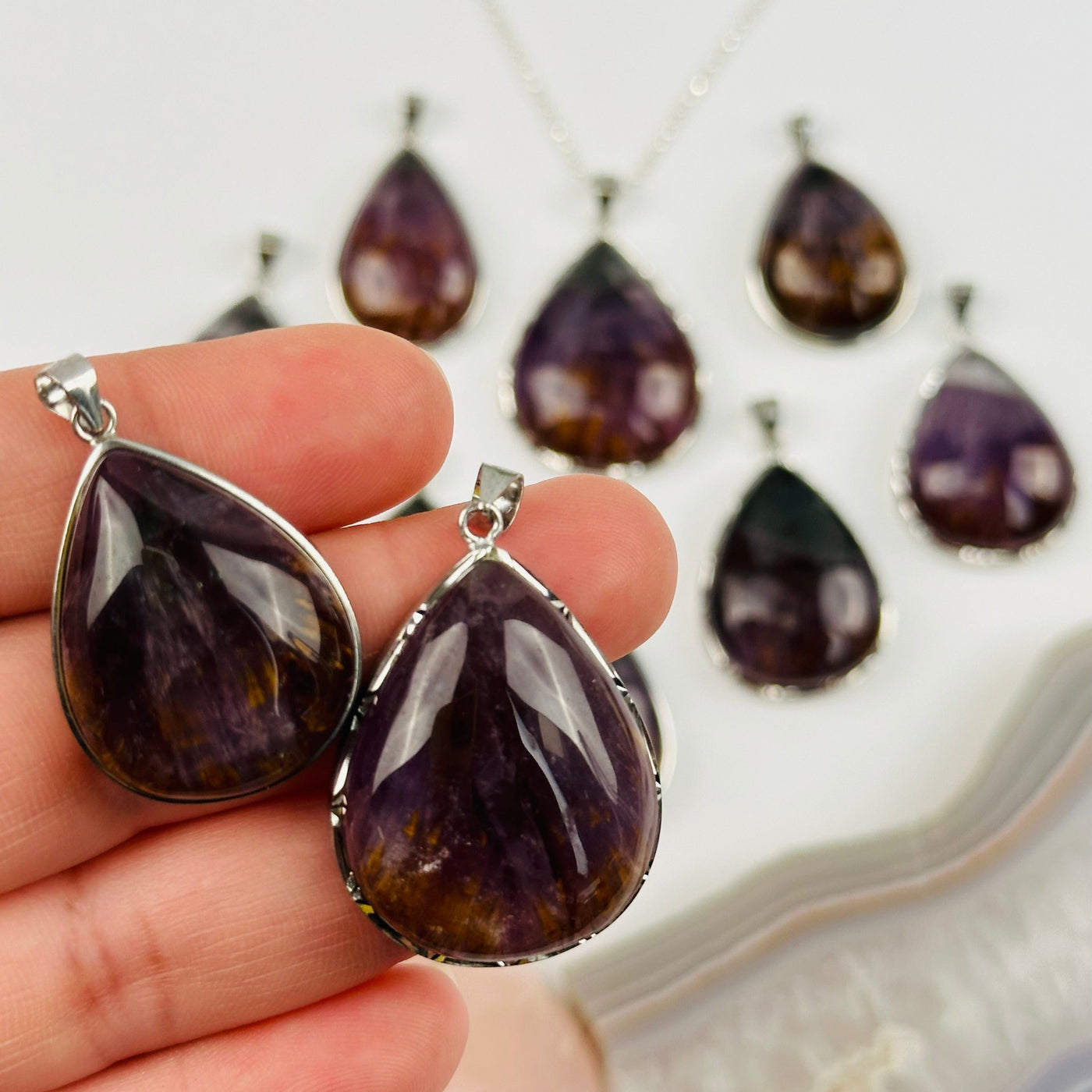 Amethyst with Golden Cacoxenite Sterling Silver Pendants in hand for size reference 