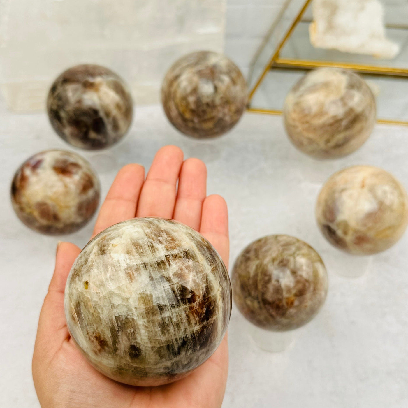 Cream Moonstone Sphere in hand for size reference 