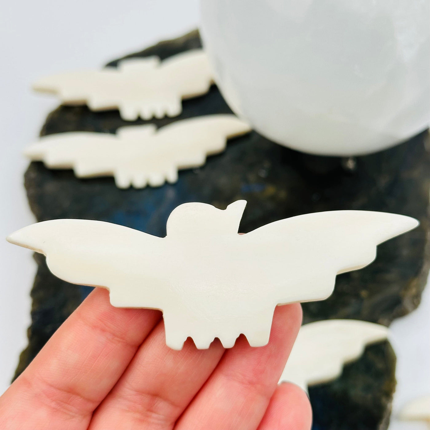 carved bone bat in hand for size reference 