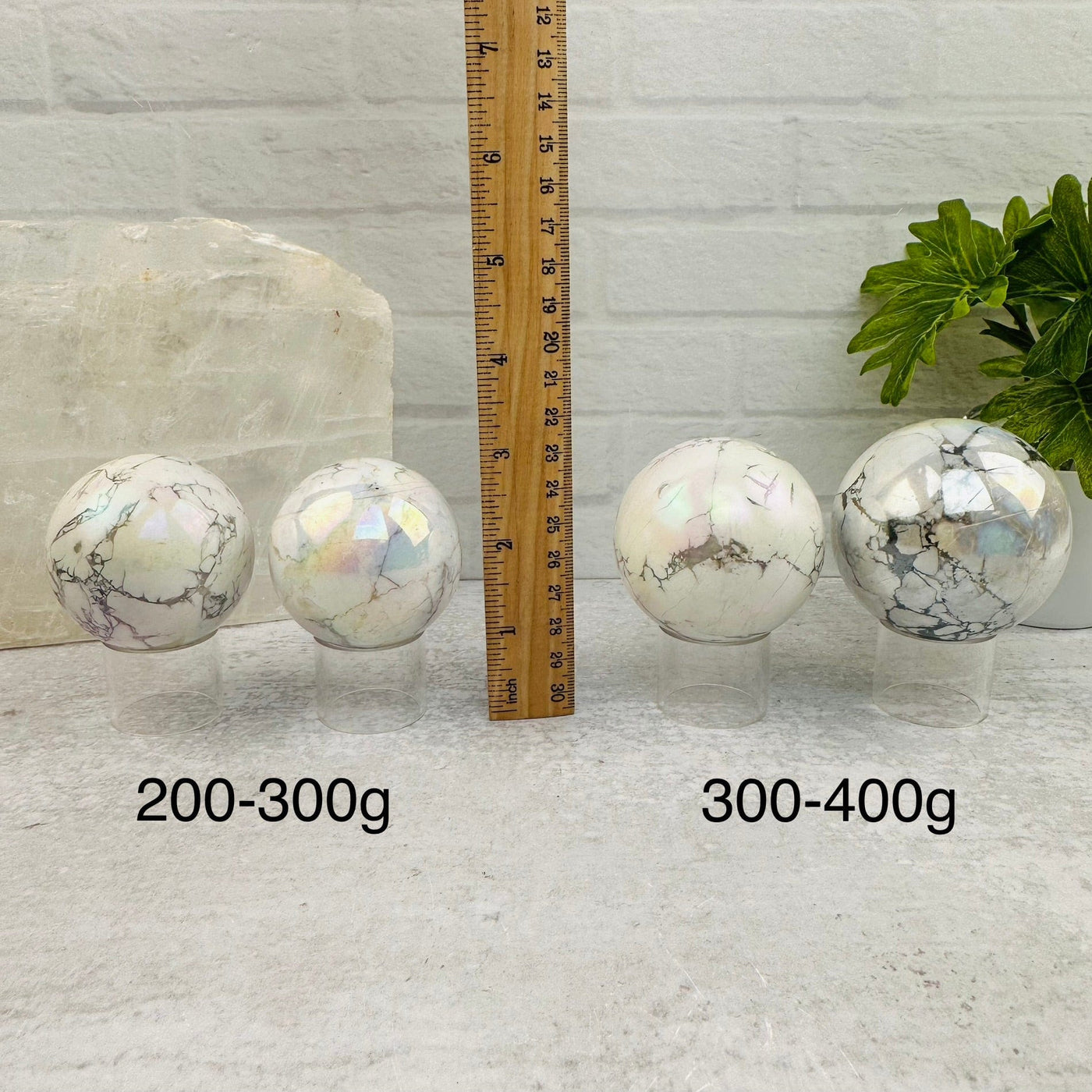 White Howlite Angel Aura Polished Spheres - By Weight - next to a ruler for size reference 