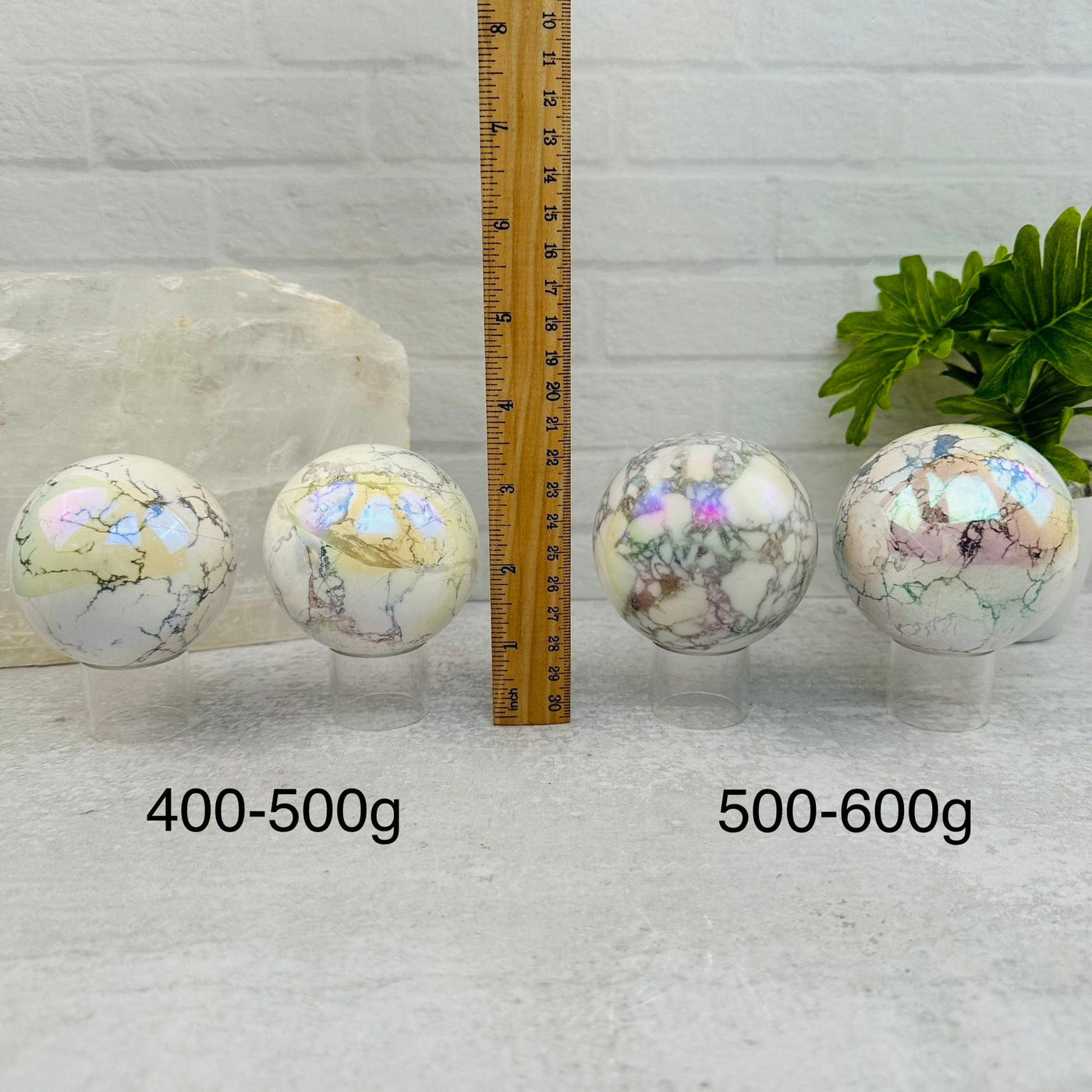White Howlite Angel Aura Polished Spheres - By Weight - next to a ruler for size reference