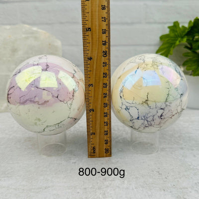 White Howlite Angel Aura Polished Spheres - By Weight - next to a ruler for size reference