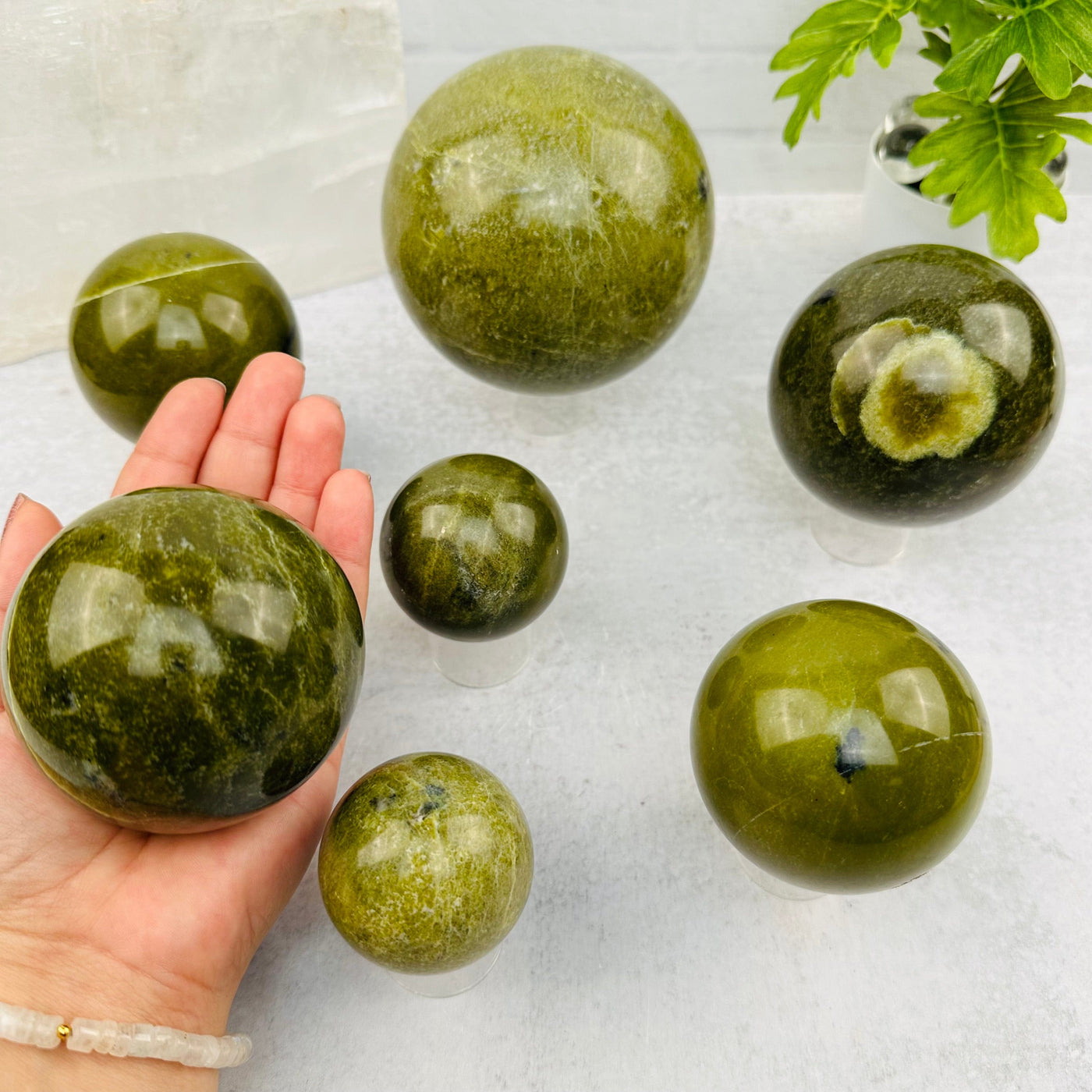 Green Jade Polished Sphere in hand for size reference 