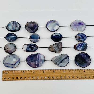 agate beads displayed next to a ruler for size reference 
