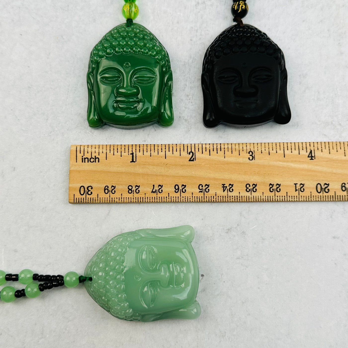 carved gemstones next to a ruler for size reference 