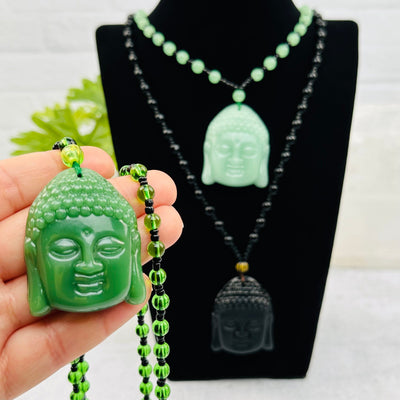 Carved Gemstone Buddha Head Mala Necklace in hand for size reference